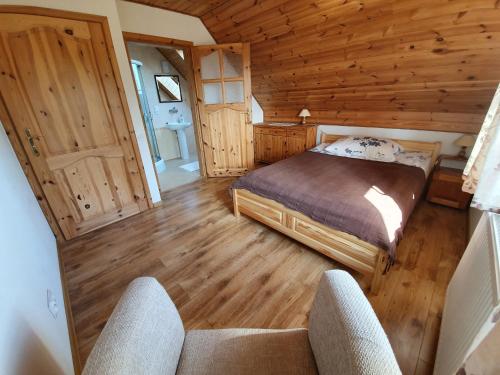a bedroom with a bed in a wooden cabin at "Pod Szumiącą Topolą" in Białowieża