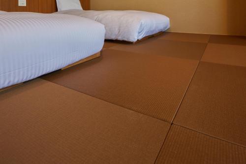 a bedroom with a brown tiled floor with a bed at Hakone Yutowa in Hakone