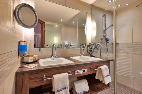un bagno con due lavandini e una doccia di Angerhof Sport- u. Wellnesshotel a Sankt Englmar