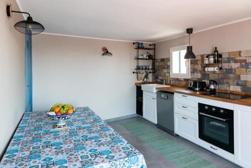 een keuken met een tafel met daarop een schaal fruit bij La terrazza dei Normanni in Aci Castello