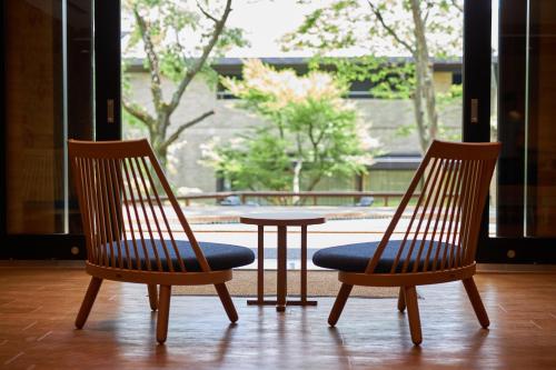 two chairs with a table in front of a window at Hakone Yutowa in Hakone