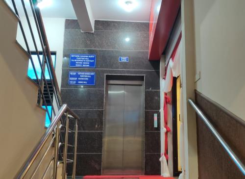 a elevator in a building with signs on the wall at Suvarna Suits in Mysore
