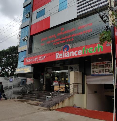 a building with a red sign on the side of it at Suvarna Suits in Mysore
