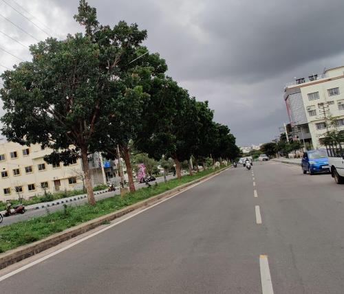 an empty street with trees on the side of the road at Suvarna Suits in Mysore