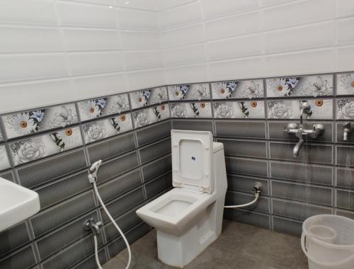 a bathroom with a toilet and a sink at Suvarna Suits in Mysore