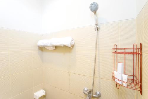 a bathroom with a shower with a towel on the wall at Griya Damai Syariah Yogyakarta Mitra RedDoorz in Yogyakarta