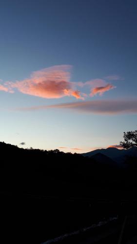 a blue and orange sky with a tree in the foreground at Mas Lo Faix in Saint-Laurent-de-Cerdans