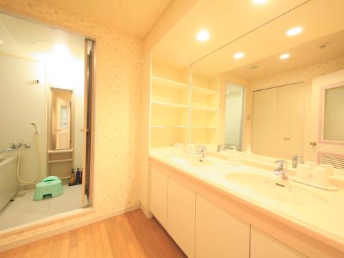 baño con 2 lavabos y espejo grande en Reyzenit Kinosaki Suite VILLA, en Toyooka