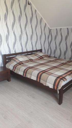 a bed sitting in a room next to a wall at Відрада in Myrhorod