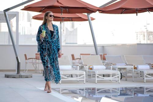 a woman in a dress standing under an umbrella at Novotel Sharjah Expo Centre in Sharjah