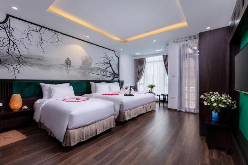 um quarto de hotel com duas camas e um quadro na parede em Hanoi Center Silk Lullaby Hotel and Travel em Hanói