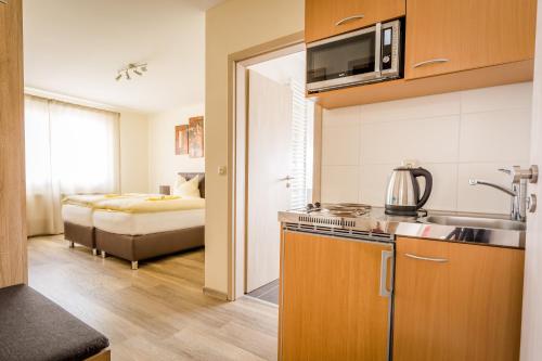 eine Küche mit einem Waschbecken und ein Zimmer mit einem Bett in der Unterkunft Boardinghaus Modern Living in Röttenbach