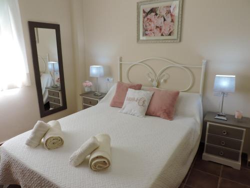 Un dormitorio con una cama blanca con toallas. en Urbanización Manilva Beach 21, en Manilva