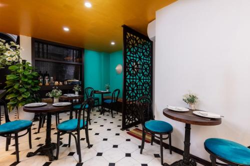 um restaurante com mesas e cadeiras e uma parede verde em Hanoi Center Silk Lullaby Hotel and Travel em Hanói