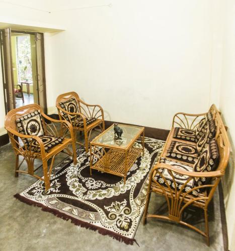 a room with chairs and a table and a rug at Blissful Eyrie in Guwahati