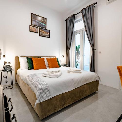 une chambre avec un grand lit et une grande fenêtre dans l'établissement 7Br 7 En-suite seafront house jacuzzi, à San Ġiljan