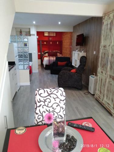 a kitchen and living room with a table and chairs at Loft "Coqueto" Rojo in Ubrique