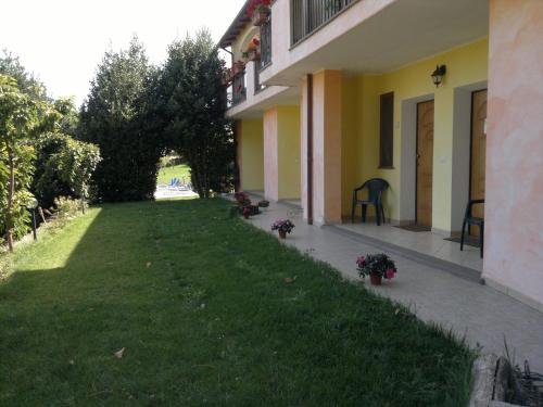 a green yard next to a building with flowers on it at Agriturismo Francadu in Santu Lussurgiu