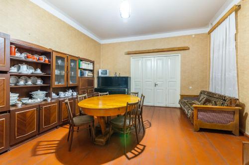 a dining room with a table and a couch at The Kiwi House in Lagodekhi