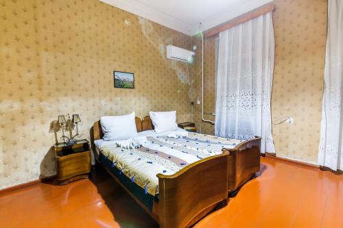 a bedroom with a large bed with a window at The Kiwi House in Lagodekhi
