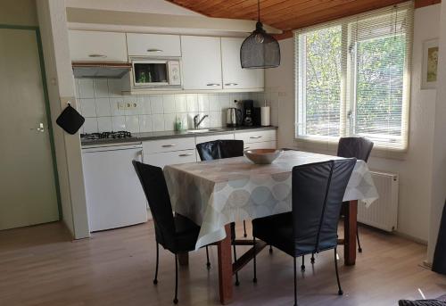 eine Küche mit einem Tisch mit Stühlen und einem Tischtuch in der Unterkunft Vakantiebungalow Oase in Exloo