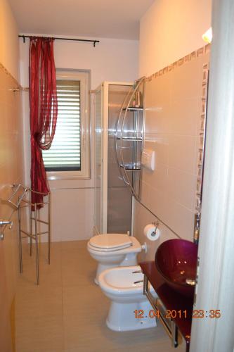 łazienka z 2 toaletami i prysznicem w obiekcie Oasi Peppa w mieście Ascea