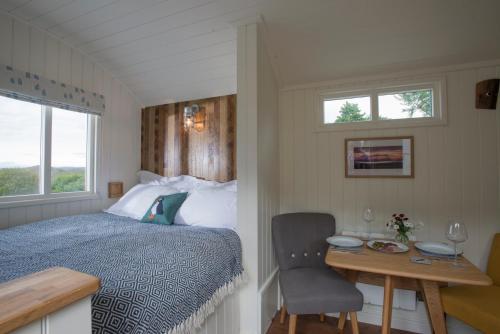 a bedroom with a bed and a desk with a chair at West Coast Hideaways in Nedd