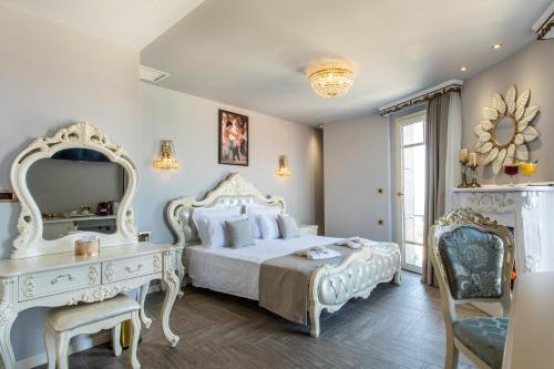 a bedroom with a bed and a dresser and a mirror at Wellness Santa Hotel - adults plus12 in Agia Triada