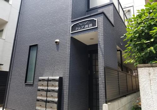 un edificio de ladrillo negro con un cartel. en Yotsuya House en Tokio