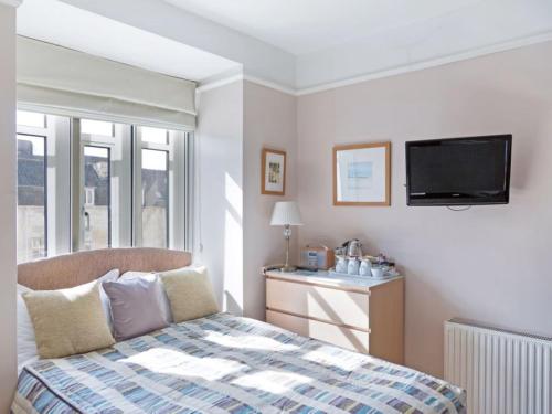 a bedroom with a bed and a flat screen tv at Bay Tree House in Bath