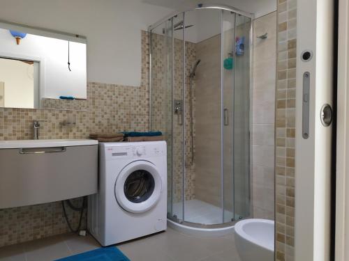 een badkamer met een wasmachine en een douche bij Giardino in laguna in Murano