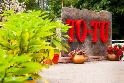 a sign for a hotel with plants in front of it at To Tu in Mrągowo