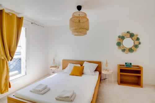 a bedroom with a bed with yellow pillows and a window at NOCNOC - Villa Paradis, piscine et rooftop au coeur de Nantes in Nantes