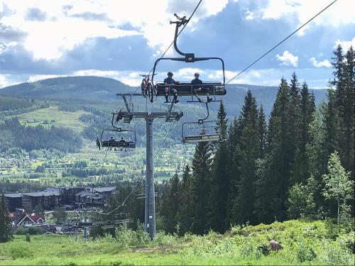 two people riding a ski lift in the mountains at Lillebjørn in Trysil