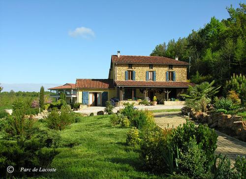 a large house with a garden in front of it at Parc Lacoste in Saint-Marcet
