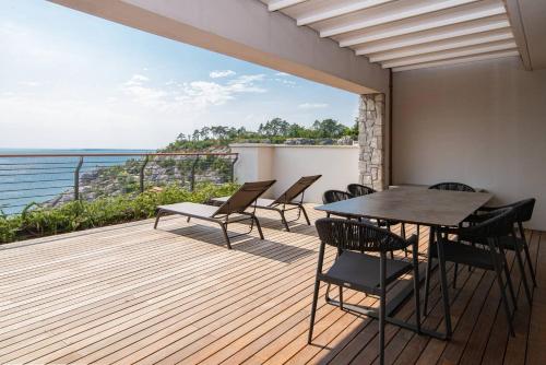 a balcony with tables and chairs and a view of the ocean at PORTOPICCOLO Luxury Penthouse Beach Included in Sistiana