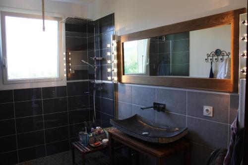 une salle de bain avec un lavabo et un miroir dans l'établissement Chez Marius, à Lagorce