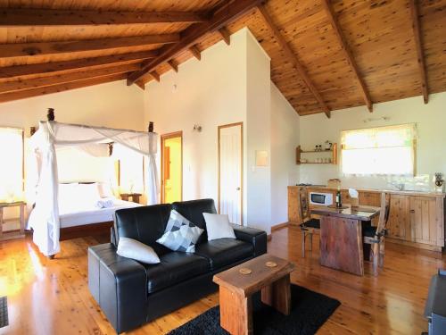 a living room with a couch and a bed at Pencil Creek Cottages in Mapleton