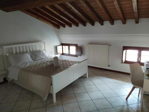 a bedroom with a large bed and two windows at Carducci 49 in Mantova