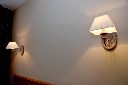 two lights on a wall in a room at Hôtel Héliot, Cosy Places by Charme & Caractère in Toulouse