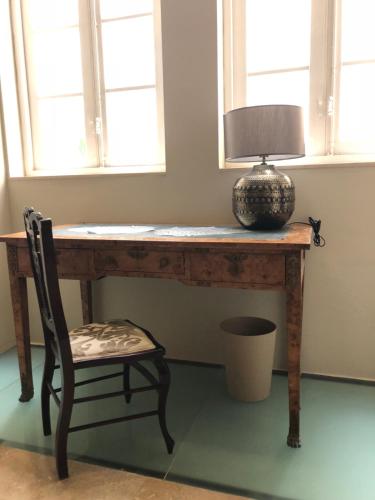 a wooden table with a lamp and a chair at Sliema La Loggia Suites in Sliema