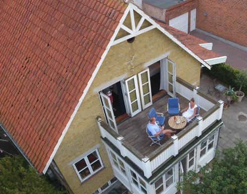 two people sitting on the balcony of a house at Villa Wiegand - a room with a view in Holbæk