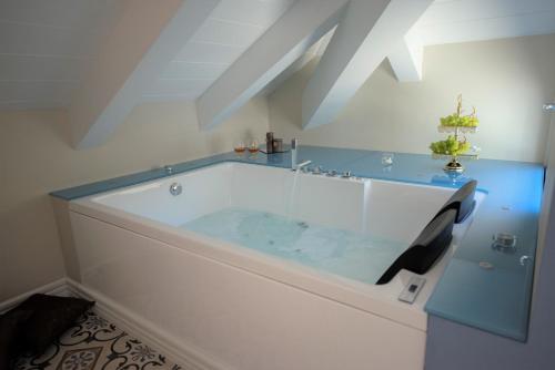 a large bath tub in a white room with at Sui Generis Tropea Luxury Rooms in Tropea