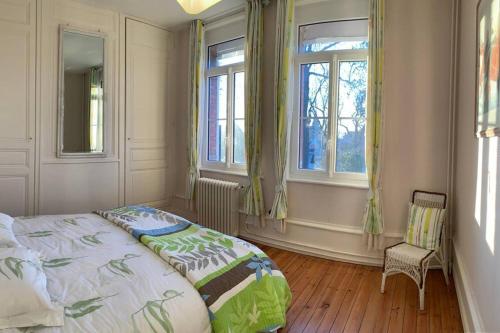 une chambre avec un grand lit et deux fenêtres dans l'établissement Gîte de Lafleur, à Dury