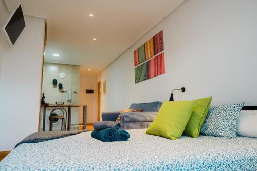 um quarto com uma cama com almofadas verdes e azuis em Apartamento Moderno, Madrid Centro em Madri