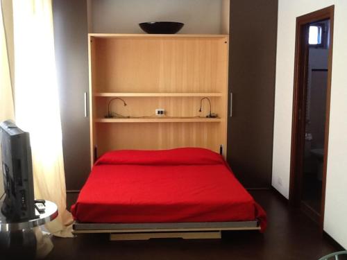 un letto con copriletto rosso in una stanza di Casa Turati a Bari
