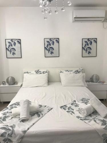 una camera da letto con un grande letto bianco con asciugamani di Studio Angel stan na dan Novi Sad a Novi Sad