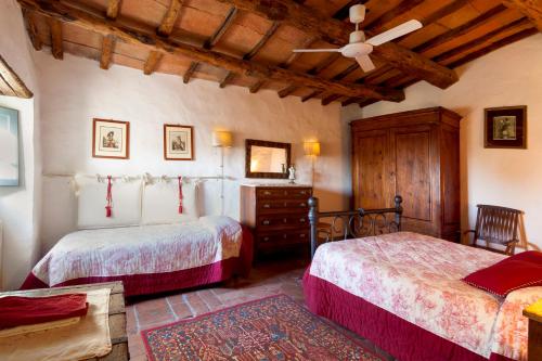 1 dormitorio con 2 camas y ventilador de techo en Mezzano In Chianti, en Strada