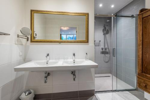 La salle de bains est pourvue d'un lavabo, d'un miroir et d'une douche. dans l'établissement The Old Lady, à Amsterdam