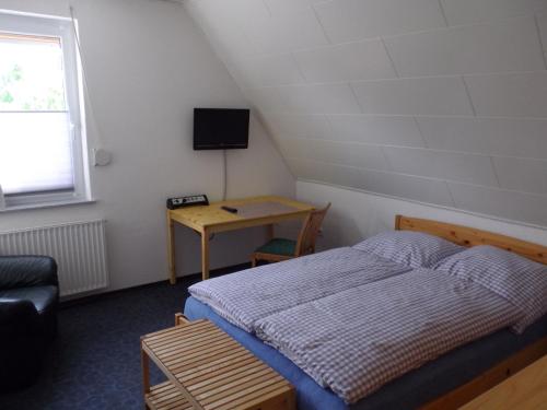 een kleine slaapkamer met een bed en een bureau bij Ferienwohnung Fritzke in Lemförde